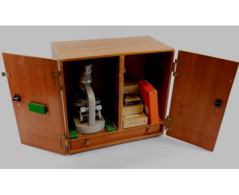 A Regent Senior microscope, various lenses, accessories, in a mahogany case.