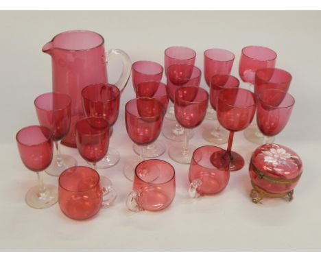 Various items of cranberry glass, to include a jug, a box and cover with gilt metal mounts and enamel decoration, and various
