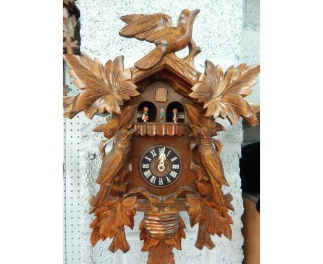 A Black Forest type cuckoo clock, mounted with two birds, 34cm high
