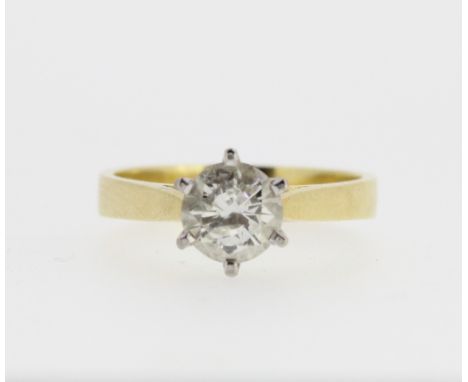 18ct yellow gold diamond solitaire ring, the round cut diamond in a white gold Tiffany style setting, on tapered shoulders an