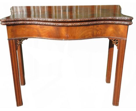 George III serpentine mahogany folding tea table with rosette carved edge, single gate action on square moulded supports with