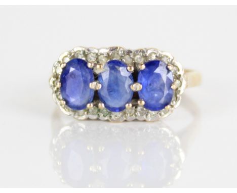 9ct yellow gold diamond and sapphire ring, set with three oval cut sapphires surrounded by a border of brilliant cut diamonds