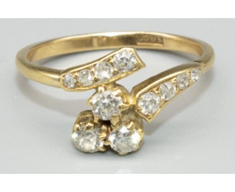 18ct yellow gold diamond twist ring, the cluster of three round cut diamonds in claw settings, on diamond set twist shoulders