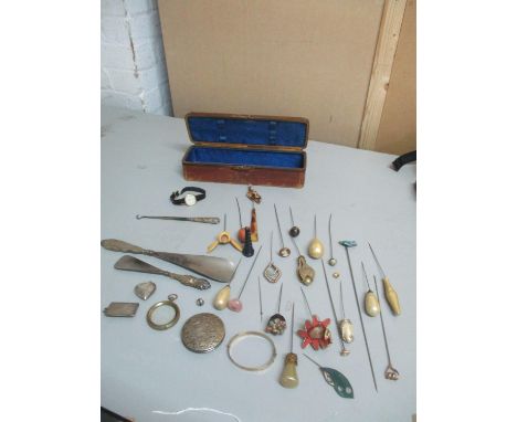 A Victorian leather glove box containing various hat pins including one with an enamelled swallow finial, two silver handled 