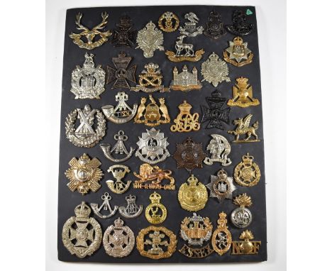 Mounted display of approximately 40 British Army metal badges including Essex Regiment, Rifle Brigade, Cameron Highlanders, N