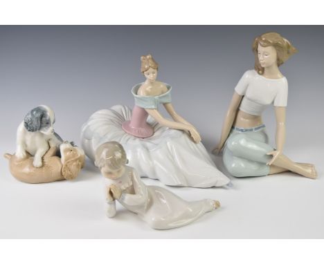 Four Nao figurines including a seated girl in a ballgown, puppies playing etc, tallest 22cm