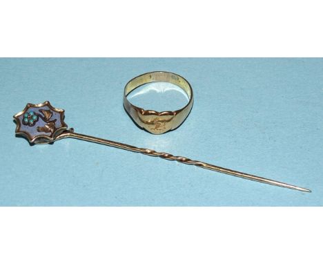 A signet ring, unmarked, tested as high carat gold, approximately 18ct, size M½, 3.6g and an enamelled locket-back stick pin,