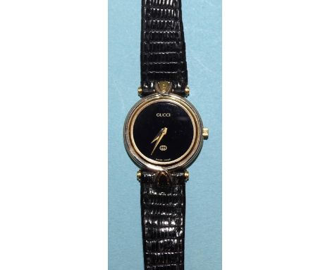 Gucci, a lady's gold-plated wrist watch with black dial and quartz movement, on leather strap, (in original case).