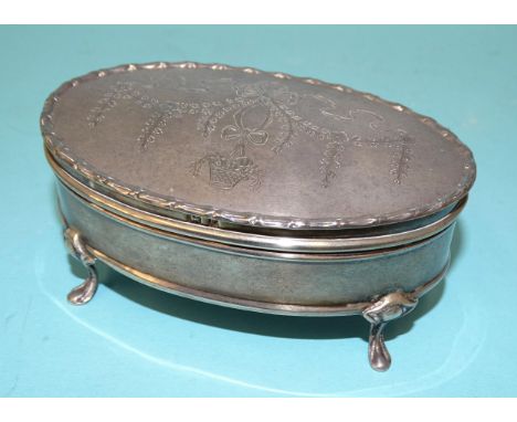 An Edwardian silver oval trinket box with swag-engraved lid and raised on four cabriole legs, maker Synyer &amp; Beddoes, Bir