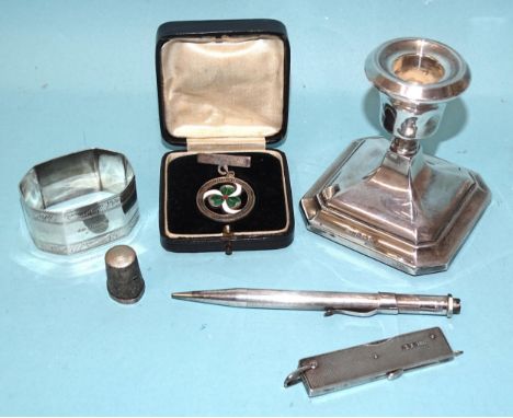 A small silver loaded-base candlestick, 7.5cm high, Birmingham 1958, a napkin ring, Birmingham 1927, a silver-cased pipe smok