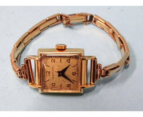 Huguenin, a lady's square-faced wrist watch with 18ct gold case, on 9ct gold expanding bracelet, gross weight 17.2g.