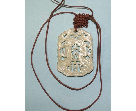 A Chinese celadon jade pendant with pierced and carved decoration, 56 x 41mm, on woven and knotted silk cord.