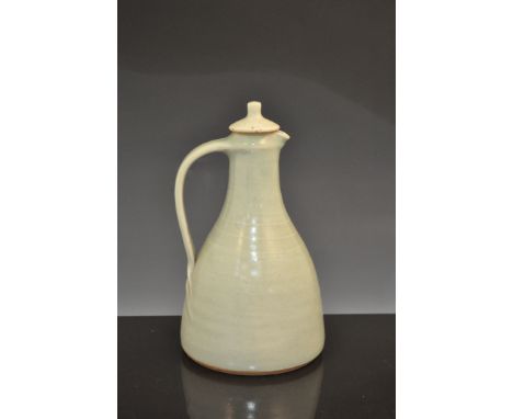 A Leach Pottery jug with cover, circa 1970, stoneware, pale olive glaze, impressed Leach Pottery seal, 20.8cm high.