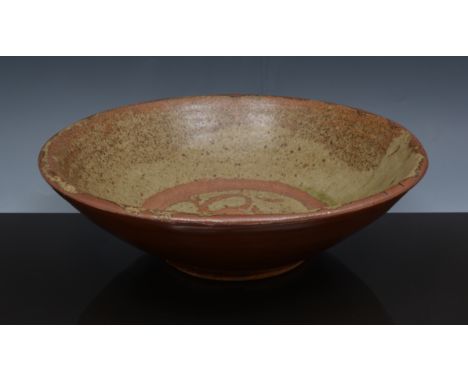 A Bernard Leach bowl, circa 1950, stoneware, the interior with olive glaze with wax resist floral motif to well, the exterior