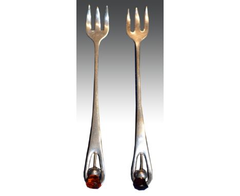 A pair of silver plated pickle forks, in the style of Charles Horner, thistle handles set with amethyst and citrine coloured 