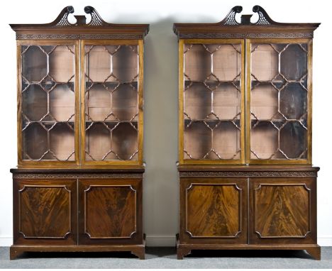 A near pair of Chippendale style mahogany bookcases, 19th Century, each with broken swan neck pediments, rosettes and fretwor