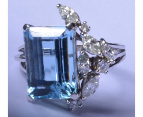 An Aquamarine and diamond dress ring, white metal set, with a large step cut aquamarine, 15mm x 10mm, offset clustered with f