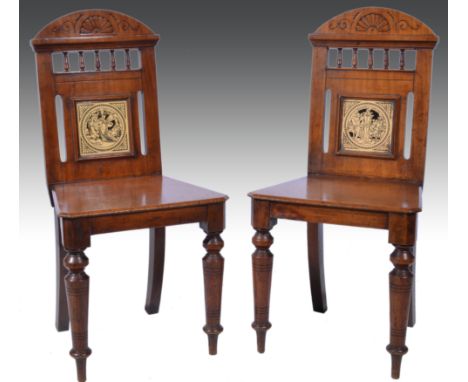 A pair of late Victorian mahogany hall chairs, circa 1890, the arched back carved with stylised motifs and a row of turned sp