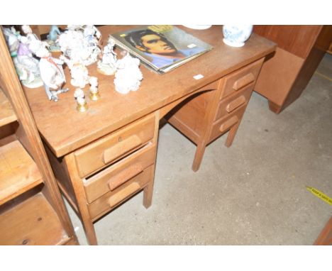 A light oak writing desk fitted six drawers