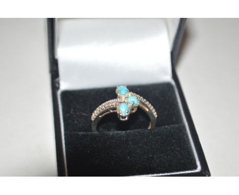 A 925 silver and turquoise set cross over ring 