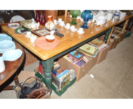 A modern pine dining table raised on green painted base