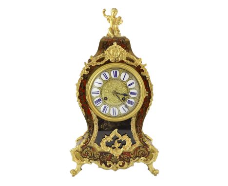 An early 20th century French ormolu mounted red boulle work mantel clock, with putto finial and Roman tablet numeral dial, ei