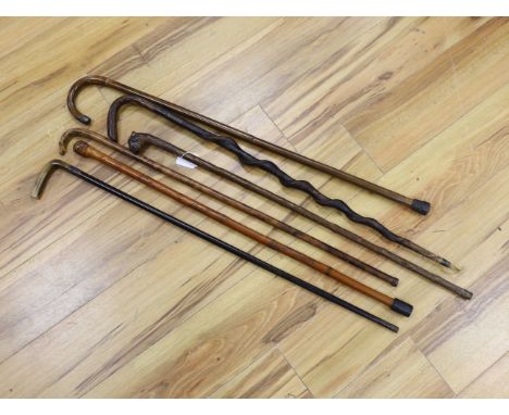 Six assorted walking sticks: a spiral carved cane, a silver mounted, a horn handled, a carved dog  handled and a carved horse