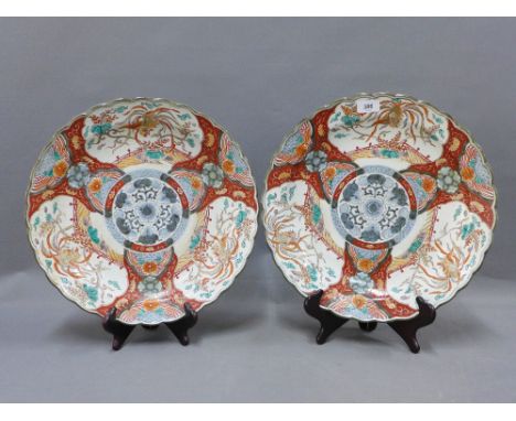 A pair of famille verte chargers, with scalloped rims, painted with birds and foliage, with underglaze blue and white central