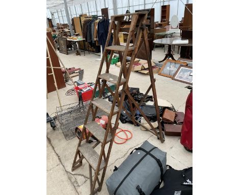 A SET OF VINTAGE WOODEN STEP LADDERS WITH CAST IRON FITTINGS 