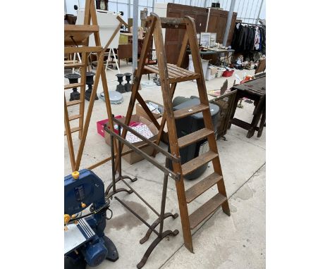 A SET OF VINTAGE WOODEN STEP LADDERS AND A PAIR OF VINTAGE CAST IRON TRESSTLES 