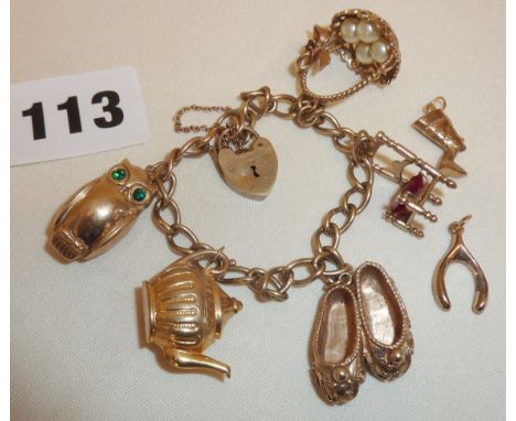 9ct gold charm bracelet, with several gold charms, (most hallmarked)  inc. teapot, owl, chair with red gem seat, basket of eg