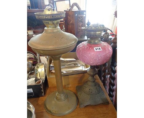Victorian oil lamp with pink opaque glass reservoir and a brass column oil lamp base