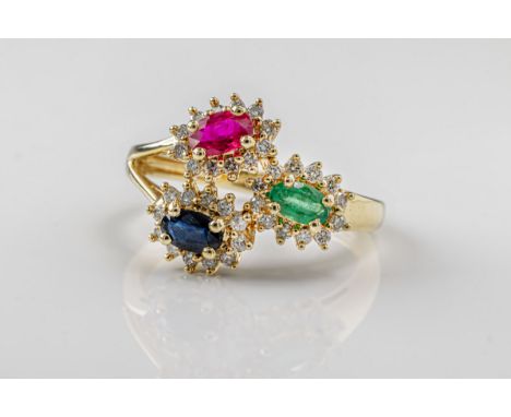  A ruby, emerald, sapphire and diamond ring in 9ct yellow gold, designed with with three cluster heads, each set with and ova