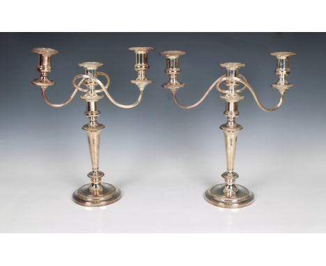 A pair of silver plate on copper twin branch candelabra by Mappin and Webb, having tapering columns to reeded branches, rais