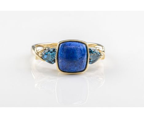  A lapis lazuli and topaz ring in 9ct yellow gold, set with a cabochon lapis lazuli and trillion-cut blue topaz to each shoul