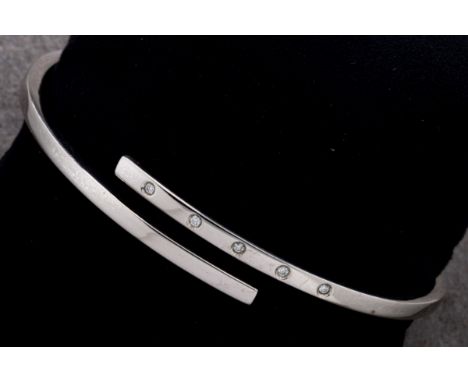  A 9ct white gold hinge bangle with inset white stones 65mm at widest. 