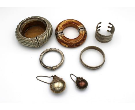  A Middle Eastern silver mounted horn bangle carved with a lion chasing an antelope, 11.4cm. diameter, together with a silver