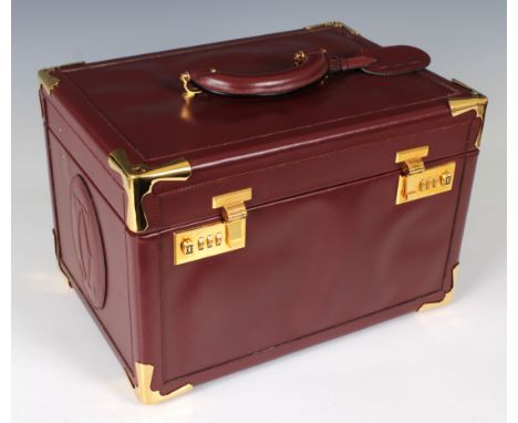  A Cartier burgundy leather vanity case with gilt metal fittings, combination locks, vanity mirror and removable leather lidd