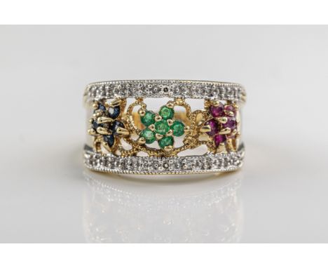  An emerald, ruby, sapphire and diamond ring in 9ct yellow gold designed with flowers in rubies, emeralds and sapphires woven