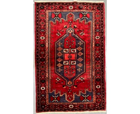 A 20th century Persian Islamic Bakhtiari floor carpet rug. The carpet having a central geometric medallion with stylized moti