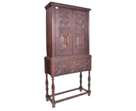 A Jacobean 18th century oak estate cupboard / bookcase cabinet on stand. The cabinet having a twin door estate cupboard atop 