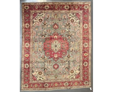 A large early 20th century North West Persian Islamic Tabriz floor carpet rug. The rug having a stylised flower shaped centra