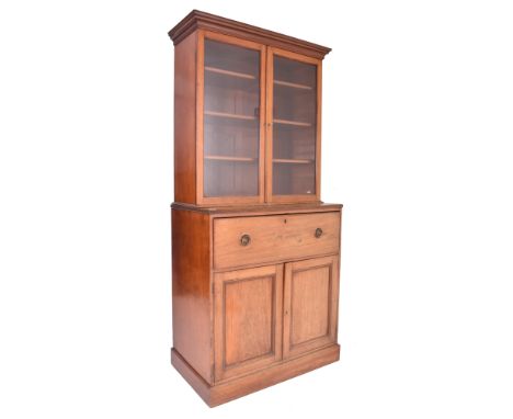 An early 19th century Sheraton Revival mahogany secretaire bookcase. The bookcase having a flared pediment atop a glazed fron