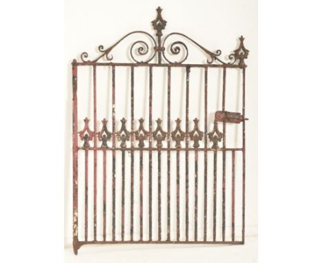 A 19th century cast iron gate door. The gate having scrolled decorations atop with shaped finials to sides. Straight railings