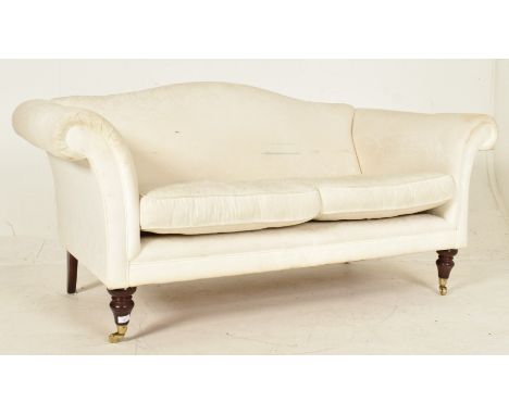 A Victorian 19th century style upholstered camel hump back two seater sofa in the manner of Howard &amp; Sons of London. The 