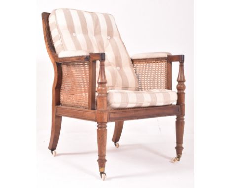 A 19th century mahogany framed bergere library armchair in the manner of Gillows. The chair having a cane worked backrest and