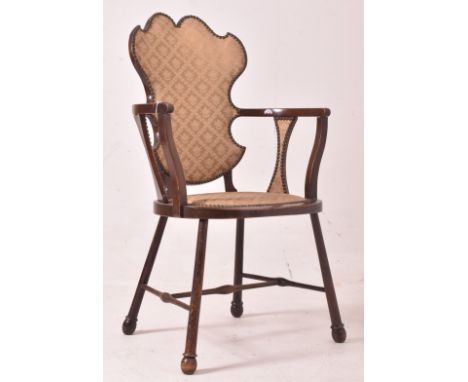 A 19th century mahogany Arts &amp; Crafts salon armchair. The chair having an upholstered armorial shaped backrest with gold 