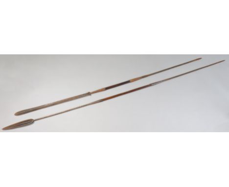 Two ethnic hunting spears, each with wooden grip, 229cm &amp; 194cm long.