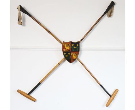 Two vintage polo mallets &amp; a painted wooden armorial plaque, mounted as a wall display, 112cm wide x 103cm high.