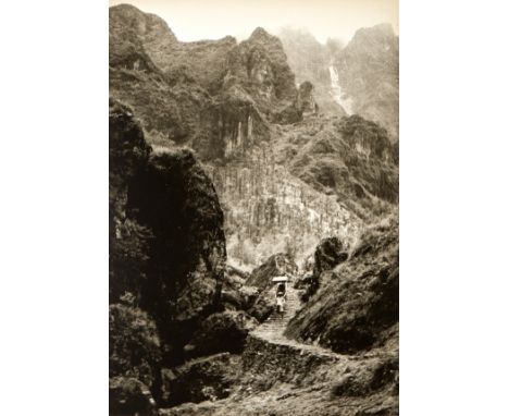 Chin San Long (Lang Jingshan) (Chinese, 1892-1995). Photograph depicting a figure carrying a load up a curving path in the mo